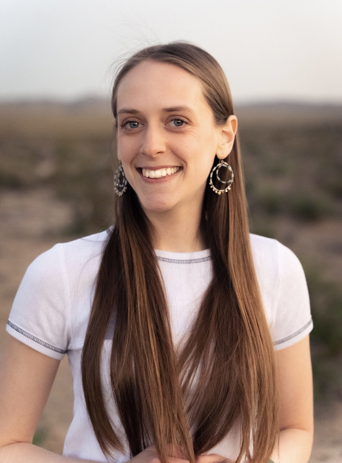Kristilee, founder of Soma Dance Method, smiling in the desert at golden hour